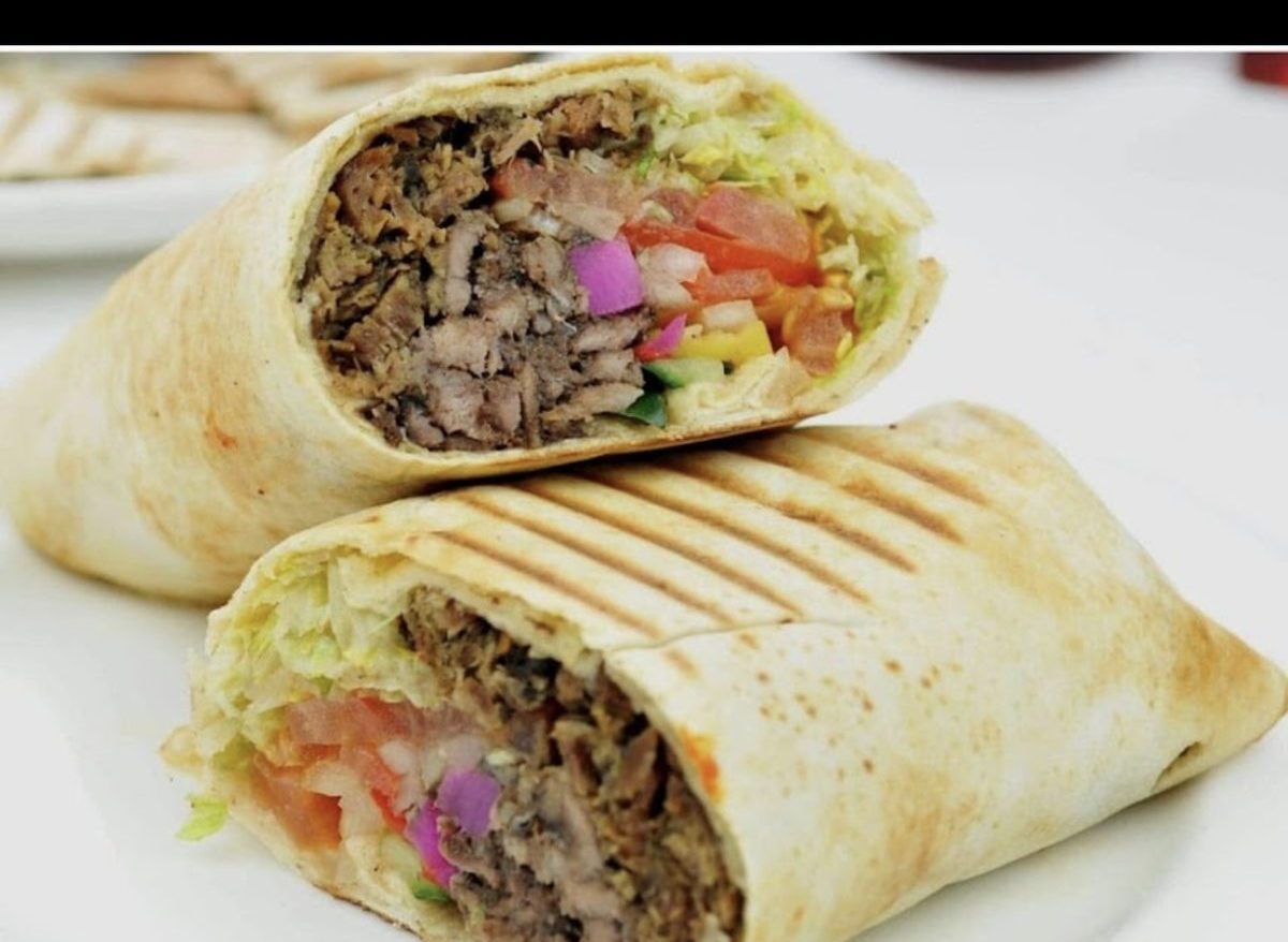 A beef kebab cut in half showing meat, salad and toasted flatbread